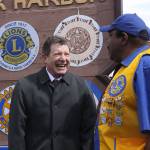 Oak Harbor Mayor Bob Severns, left, visits with Oak Harbor Lion James House in front of the city&rsquo;s welcome sign that also features the emblems of the community&rsquo;s service organizations. The Oak Harbor Lions celebrated the centennial anniversary of their parent club, Lions Clubs International, by installing a new emblem. Photo by Ron Newberry/Whidbey News-Times