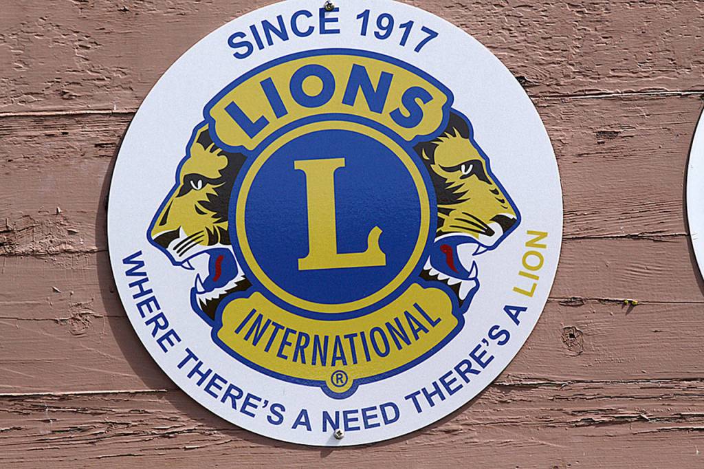 The Oak Harbor Lions installed a new emblem on Oak Harbor&rsquo;s welcome sign at the south entrance to the city in recognition of Lions Clubs International&rsquo;s centennial anniversary. Photo by Ron Newberry/Whidbey News-Times