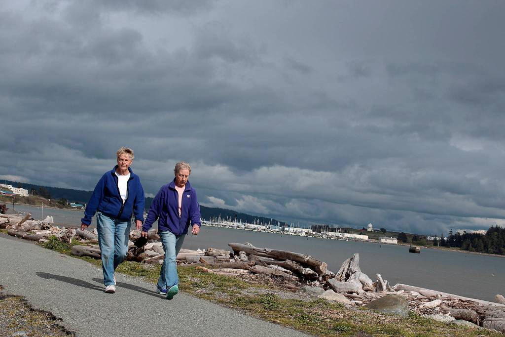 Clouds can&rsquo;t stop walkers from their daily exercise along Oak Harbor&rsquo;s shoreline.                                Photo by Patricia Guthrie/Whidbey News-Times