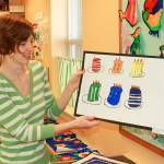 Christina Brady, the art specialist for Olympic View Elementary School, describes a student&rsquo;s piece of art which is on display in the 16th Annual Elementary Art Walk in Pioneer Way businesses. Photo by Daniel Warn/Whidbey News-Times