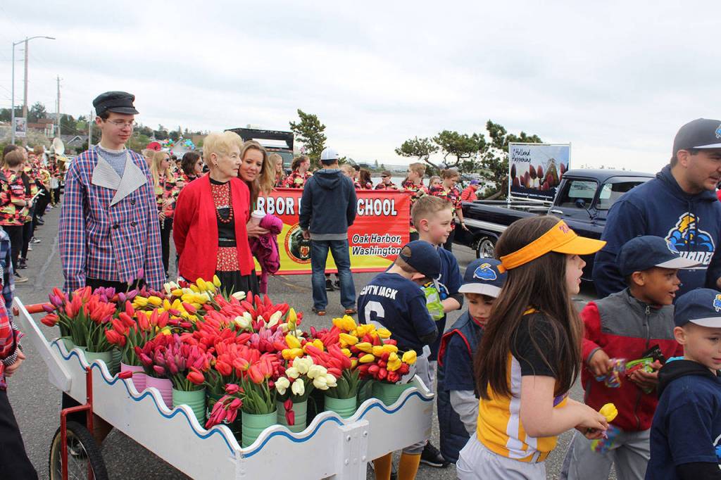 Jacob Hutson, left, and Sandy Mulkey start trekking a cart full of tulips at the beginning of the parade.