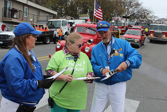 Vicki Graham, center, consults with parade organizers on the number of entries in Saturday&rsquo;s parade; 106 groups were expected. Graham planned four days of activities for Holland Happening as the events coordinator for Oak Harbor Chamber of Commerce