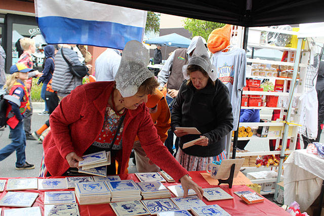Jan Boonstra, left, and Jennifer Adema arrange tiles at the booth of Holland America Koffie Klets, a group that meets monthly in Oak Harbor to discuss all things Dutch.