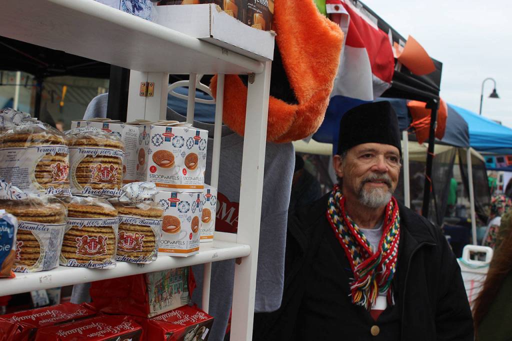 Charles Wynkoop poses in front of some Dutch cookies and wafers at the street fair on Pioneer Way. His ancestors came to the area after leaving the Utrecht region of Holland.
