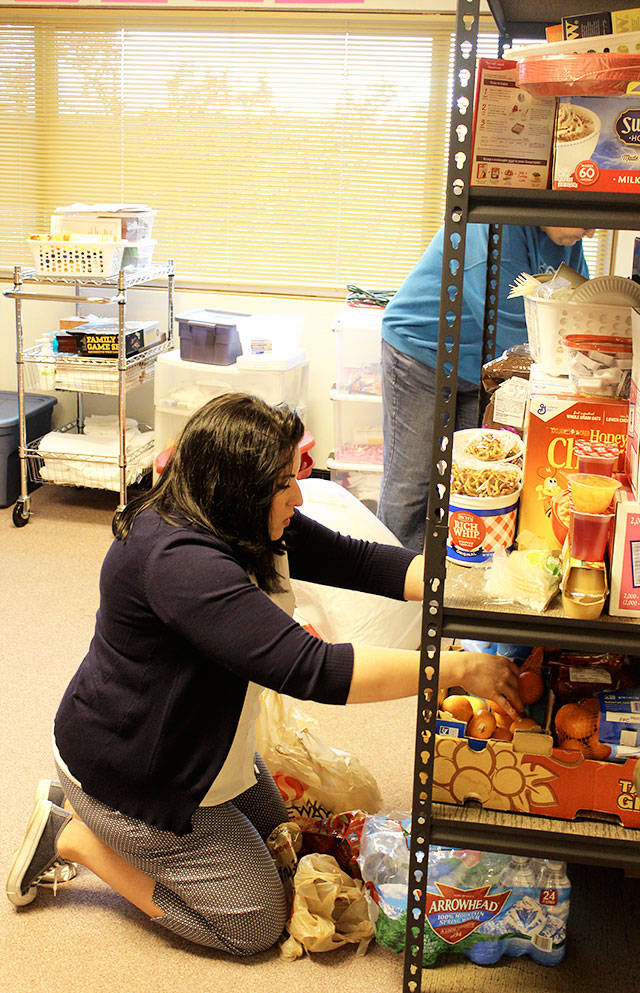 Shawna Pinder, manager of the Haven shelter, sorts out food and other supplies before guests start arriving at Christian Reformed Church fellowship hall Tuesday evening. Photo by Patricia Guthrie/Whidbey News-Times