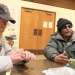 Randy Brown, left, rolls a cigarette as Mitch Riley checks his latest hand of cards. The two men were part of nine guests who stayed at the Haven shelter at Christian Reformed Church Tuesday evening. Photo by Patricia Guthrie/Whidbey News-Times