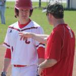 Runner Clay Reilly, left, and assistant coach Scott Hillborn discuss strategy during a break in the first inning. (Photo by Jim Waller/Whidbey News-Times)