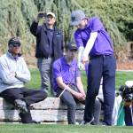With coach David Smith looking on, Nate Thompson tees off for the Wildcats. (Photo by John Fisken)