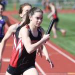 Maya Toomey-Stout takes a handoff from Mallory Kortuem as the Wolves win the 4x200 relay. (Photo by John Fisken)