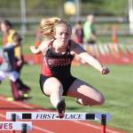 Allison Wenzel leaps a hurdle in the 300. (Photo by John Fisken)