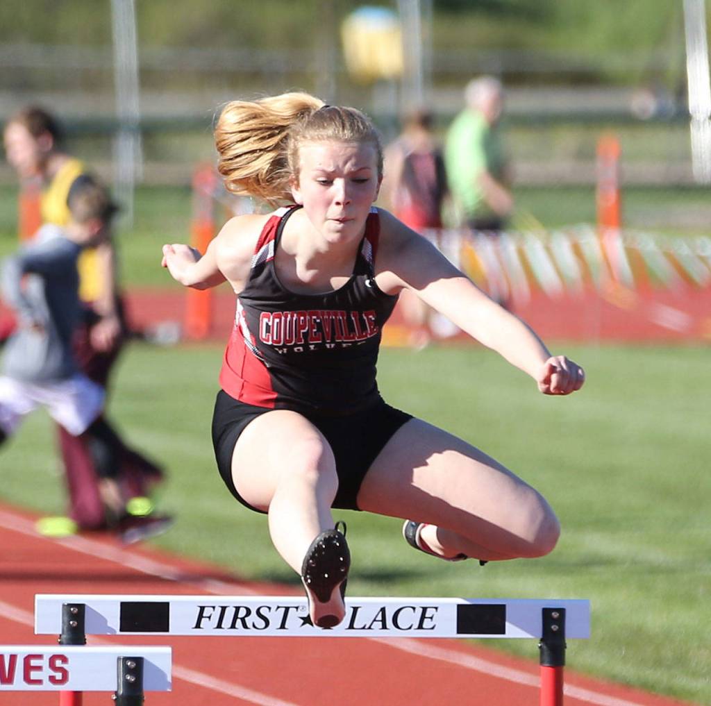 Allison Wenzel leaps a hurdle in the 300. (Photo by John Fisken)