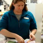 Island Drug pharmacy tech Lisa Bacolo sorts through the many prescription cards customers bring in but the one offered by the county is not among them. Photo by Patricia Guthrie/Whidbey News-Times