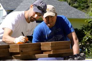 Jordan Schisel, left, determines the length of a cut during the Central Whidbey Hearts & Hammers&rsquo; annual work day Saturday, May 6, 2017 in Coupeville. The volunteer nonprofit group participated in 18 different projects to help their Central Whidbey neighbors Saturday. Photo by Ron Newberry/Whidbey News-Times