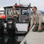 Ralph Downes, left, enforcement officer with Washington Department of Fish and Wildlife, watches as fellow officer Taylor Kimball tries to catch the attention of Popeye the harbor seal at Friday Harbor Wednesday, May 10, 2017. The enforcement officers stopped in Friday Harbor for gas. Photo by Ron Newberry/Whidbey News-Times