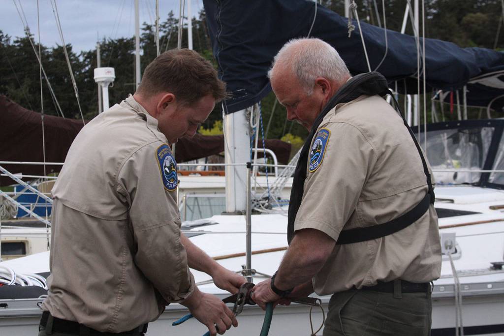 Even after arriving back in Anacortes to end the outing, the adventures continued for Washington Department of Fish and Wildlife enforcement officers Taylor Kimball and Ralph Downes as they tried to disconnect a nossle from a hose Wednesday, May 10, 2017. Photo by Ron Newberry/Whidbey News-Times
