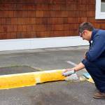Justin Green works on the parking lot of WhidbeyHealth Patient Financial Services, which consolidated offices over the weekend. The building, once Linds Pharmacy, is located at 40 N. Main Street in Coupeville. Photo by Patricia Guthrie/Whidbey News-Times