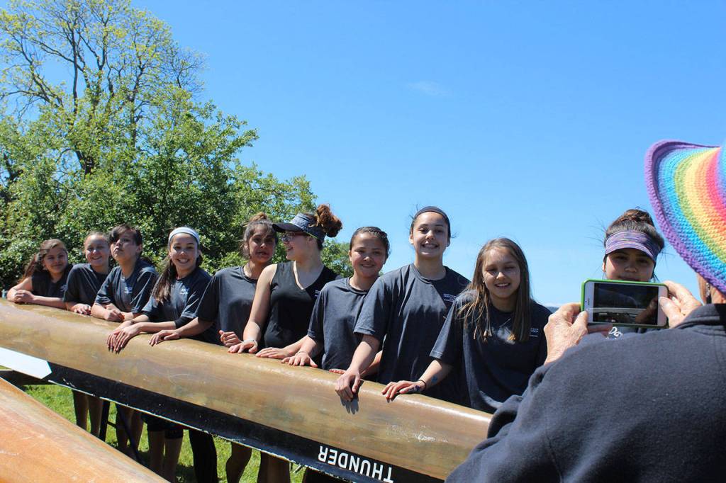 Members of the Junior Buckskin Makah Tribe team pose for a photo in front of the 48-foot red cedar canoe. The Ocean Thunder team was in the age 13-and-under race with 11 crew members.