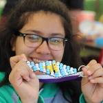 Nanci Melendrez, 15, shows off the fish she made at the children&rsquo;s activities tent while helping her sister and other kids.