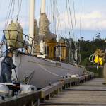 Mark Saia, right, chats with fellow captain Jonny Johnson before departing the Coupeville Wharf Wednesday. A night earlier, the 1925 schooner Suva broke free from her mooring during a nasty wind storm and ended up approaching the rocks across Penn Cove near Blowers Bluff. Saia got in an inflatable tender at the wharf and raced across the cove despite heavy gusts, high waves and increasing darkness to single-handedly rescue the boat. Photo by Ron Newberry/Whidbey News-Times