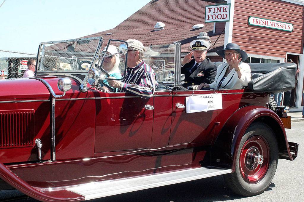 Marshall Bronson, U.S. Navy (Ret.), center, waves as he rolls through the Memorial Day Parade&rsquo;s route in Coupeville Saturday. Photo by Daniel Warn/Whidbey News-Times