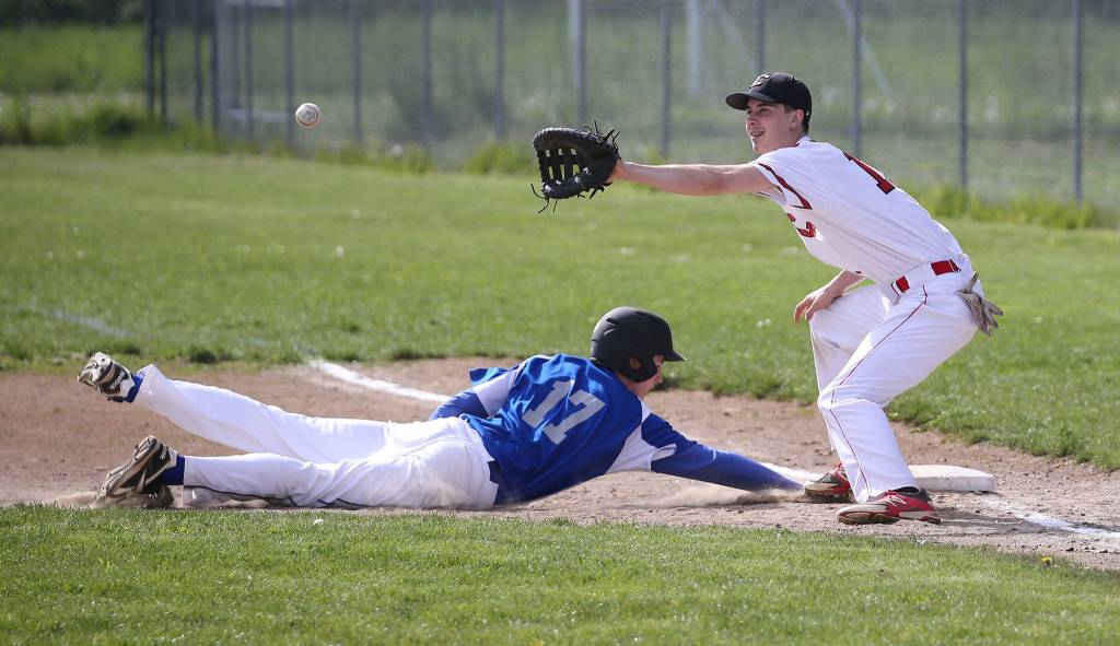 Kory Score receives a pick off throw as Jeff Jewett dives back into first base. (Photo by John Fisken).