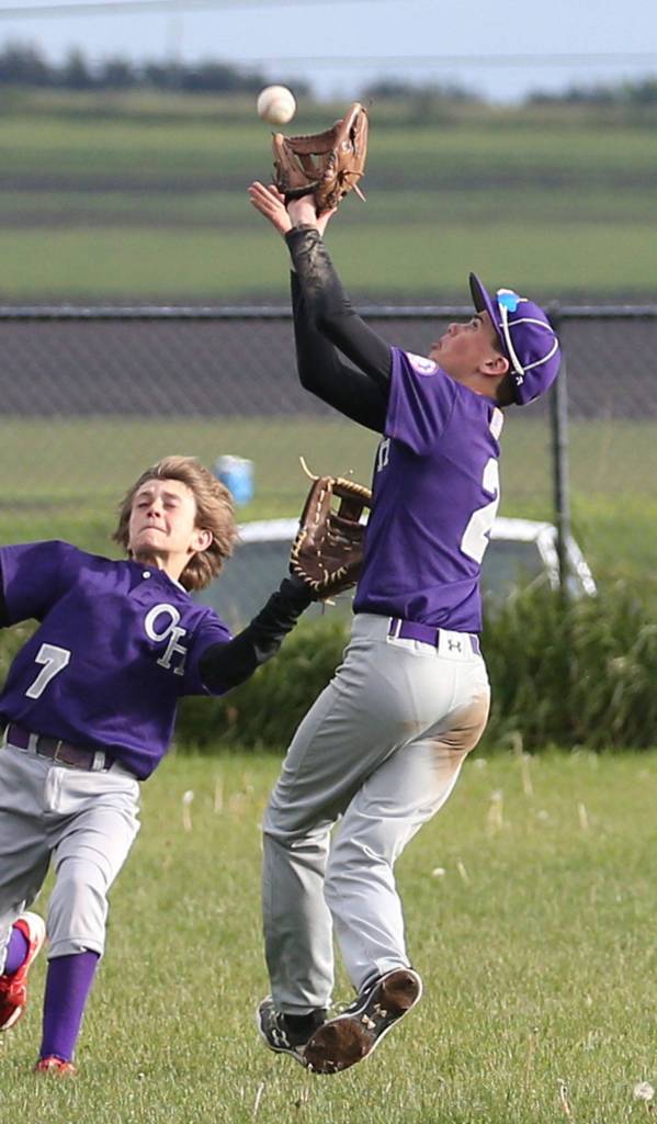 Oak Harbor shortstop Gage McLeod grabs a pop-up in front of left fielder Aidan Golden. (Photo by John Fisken)