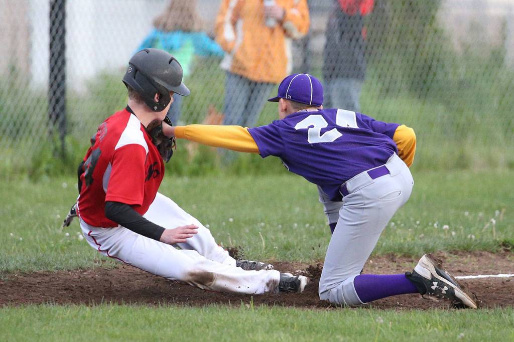 Oak Harbor&rsquo;s Jordan Ronning tags Caleb Meyer as Meyer tries to get back to third base. (Photo by John Fisken)