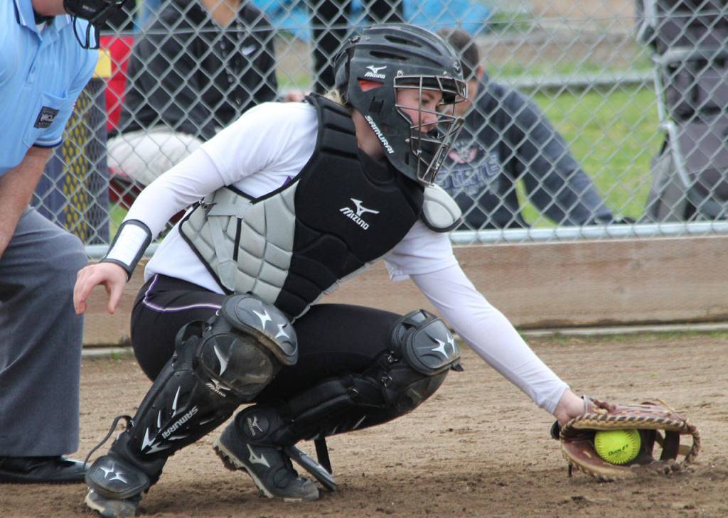 Wildcat catcher Kaitlinn Scheer scoops up a low pitch. (Photo by Jim Waller/Whidbey News-Times)