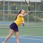 Tia Rios smashes an overhand shot while winning first singles Tuesday. (Photo by John Fisken)