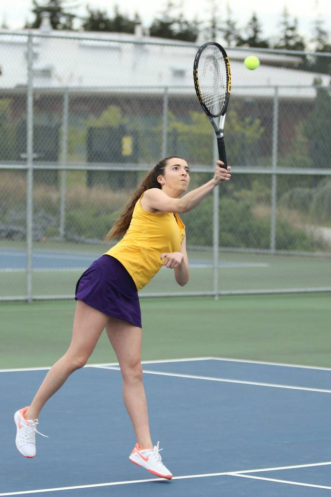 Tia Rios smashes an overhand shot while winning first singles Tuesday. (Photo by John Fisken)