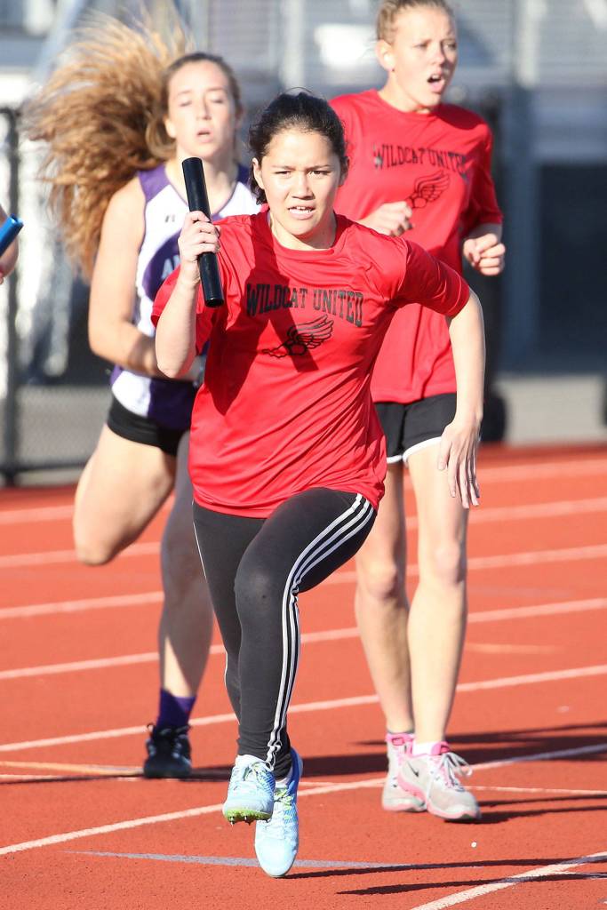 Mariko Johnston takes the baton in the eighth-grade girls winning 4x200 relay. (Photo by John Fisken)