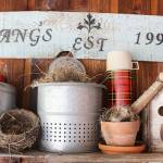 Vintage camping and cooking gear, bird nests and bird houses sit atop an old-fashioned wooden sled turned into a shelf.