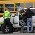 A hit-and-run accident on South Main Street in Coupeville leaves Coupeville&rsquo;s Greg Odle to contemplate what happened while emergency responders with WhidbeyHealth EMS and Central Whidbey Fire & Rescue tend to him as a school bus passes Thursday. Odle was uninjured. The driver who fled on foot was later found in a nearby field and arrested and booked into the Island County jail. Pictured in reflective vests are WhidbeyHealth EMS personnel Greg Behan, left, and Robert May, right. Next to Odle is firefighter/EMT Marvin Raavel. Photo by Ron Newberry/Whidbey News-Times