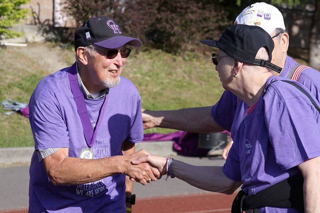 Ron Ernst, left, shakes the hand of a fellow cancer survivor during the Relay for Life of Whidbey Island event Friday, June 2, 2017, at North Whidbey Middle School in Oak Harbor. Photo by Ron Newberry/Whidbey News-Times