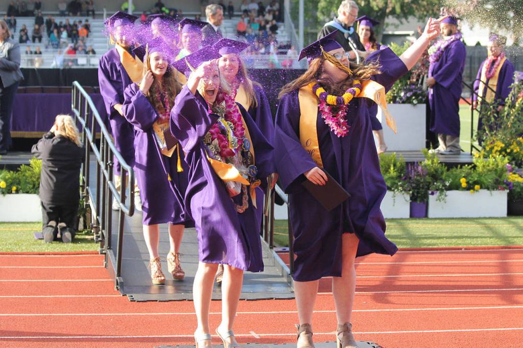 With diplomas in hand, a group of the newest Oak Harbor High School graduates celebrate with glitter at Monday&rsquo;s commencement ceremony. Photo by Daniel Warn/Whidbey News-Times