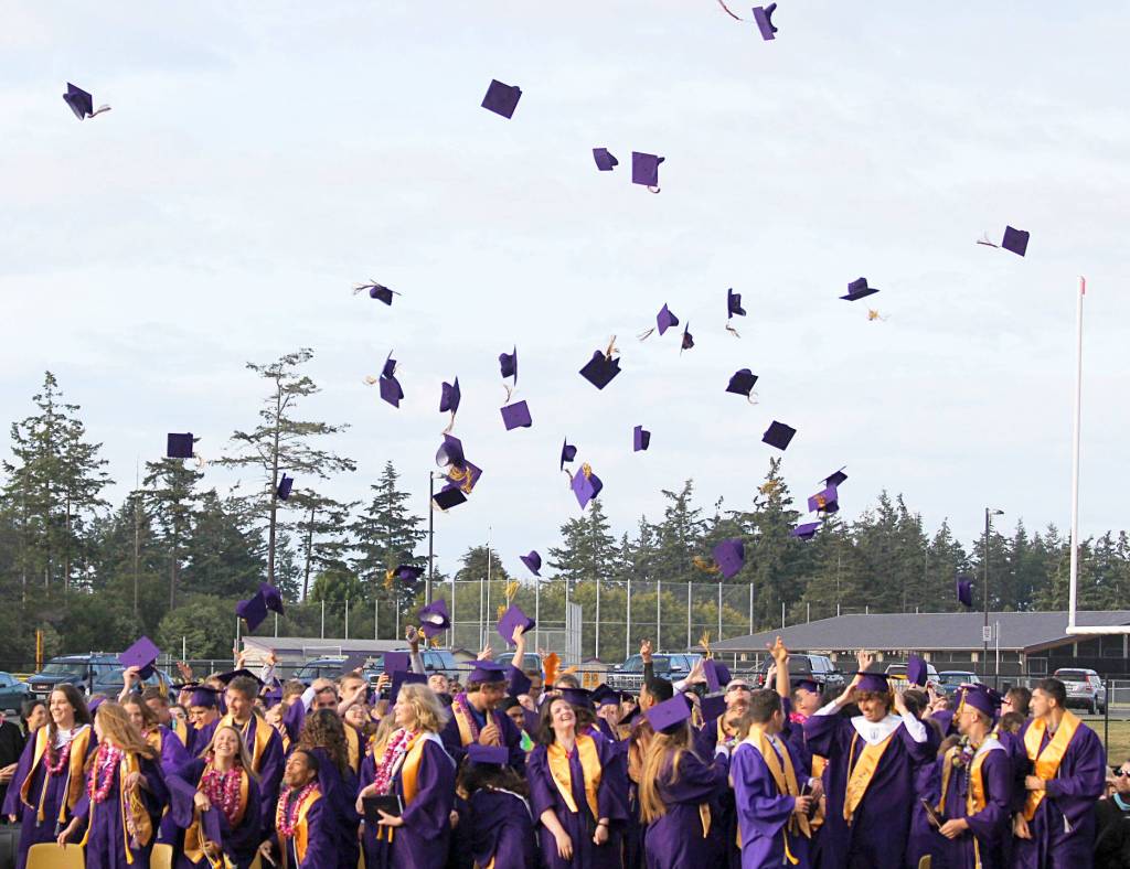 The Oak Harbor High School class of 2017 toss their caps in a surge of celebration as the commencement ceremony at Wildcat memorial Stadium come to a close Monday. Photo by Daniel Warn/Whidbey News-Times