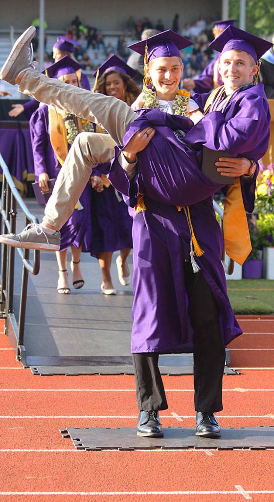 Student speaker Seth Gluth carries fellow graduate Joshua Coe down the ramp, both with diplomas in hand. Gluth of one of five student speakers of the Oak Harbor High School commencement ceremony Monday. Photo by Daniel Warn/Whidbey News-Times