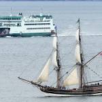 A Washington State Ferry nears a flotilla of square-rigged schooners and other sailboats Tuesday in Admiralty Inlet. The tall ships were on their way to the 2017 Festival of Sail in Tacoma, taking place this weekend. They passed Point Wilson, Admiralty Head and Marrowstone Point. Photo by John Fisken