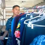 Sea Cadet Isidro Torres, 13, helps move a rack of clothing into a moving truck for Garage of Blessings Friday. The nonprofit has moved to 1751 N. Goldie Road, Oak Harbor. Photo by Daniel Warn/Whidbey News-Times