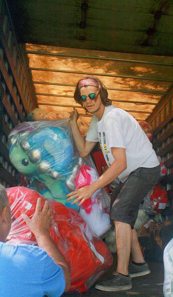 Zach Nix, from Colorado, offloads a truck full of carnival prizes Thursday at Windjammer Park in preparation for the Fourth of July Carnival. Photo by Daniel Warn/Whidbey News-Times