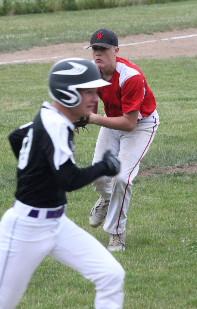 After fielding a tap back to the mound, Coupeville pitcher Gavin Knoblich, right, prepares to throw to first.(Photo by Jim Waller/Whidbey News-Times)