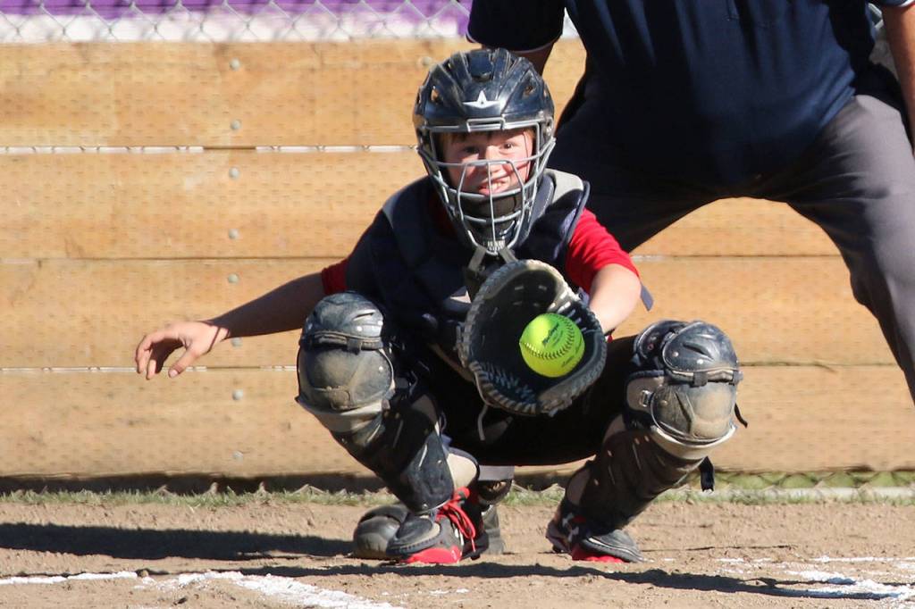 Central Whidbey catcher McKaela Meffert hauls in a pitch in the opening game. (Photo by John Fisken)