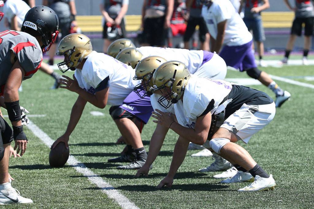 The offensive line gets ready to fire off the ball. (Photo by John Fisken)