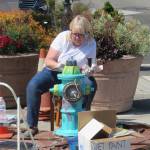 Before she moves to Santa Fe, Lizbeth Cort paints the first fire hydrant as a test for an upcoming Oak Harbor Arts Commission project. Photo provided by the Oak Harbor Arts Commission