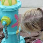 Artist Lizbeth Cort leans into the fire hydrant she painted on July 20. Photo provided by the Oak Harbor Arts Commission.