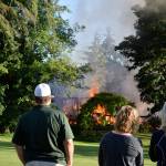 Kyle Jensen / The Record &mdash; Useless Bay Colony residents watch the scene as the house fire dies down. The blaze claimed the home, located on Capt. Vancouver Drive.