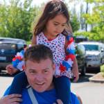 Kaci Groves, 3, gets a ride en route to the parade on the shoulders of Dad, Chris Groves.