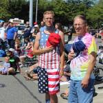 Father and son Matthew (left) and Kevin Turner take off their hats as veterans pass by carrying the American flag.