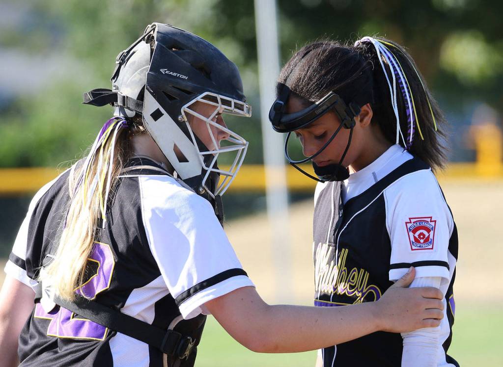 North Whidbey catcher Kayla Carr, left, consoles pitcher Macy Oliver after a rough start Thursday. (Photo by John Fisken)