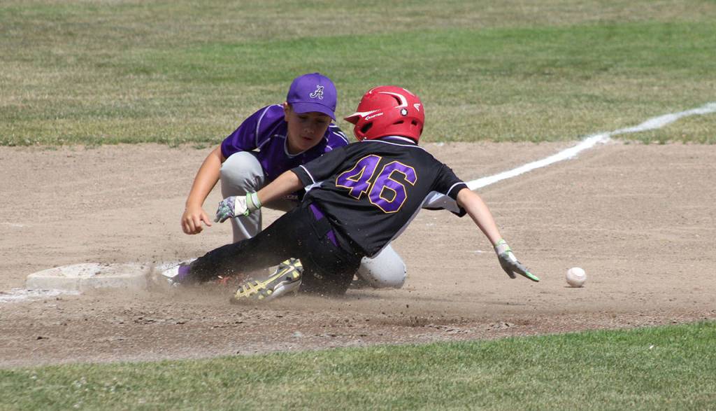 Christian Gisvold slides safely into third base as the ball slips away from the Anacortes fielder. (Photo by Jim Waller/Whidbey News-Times)